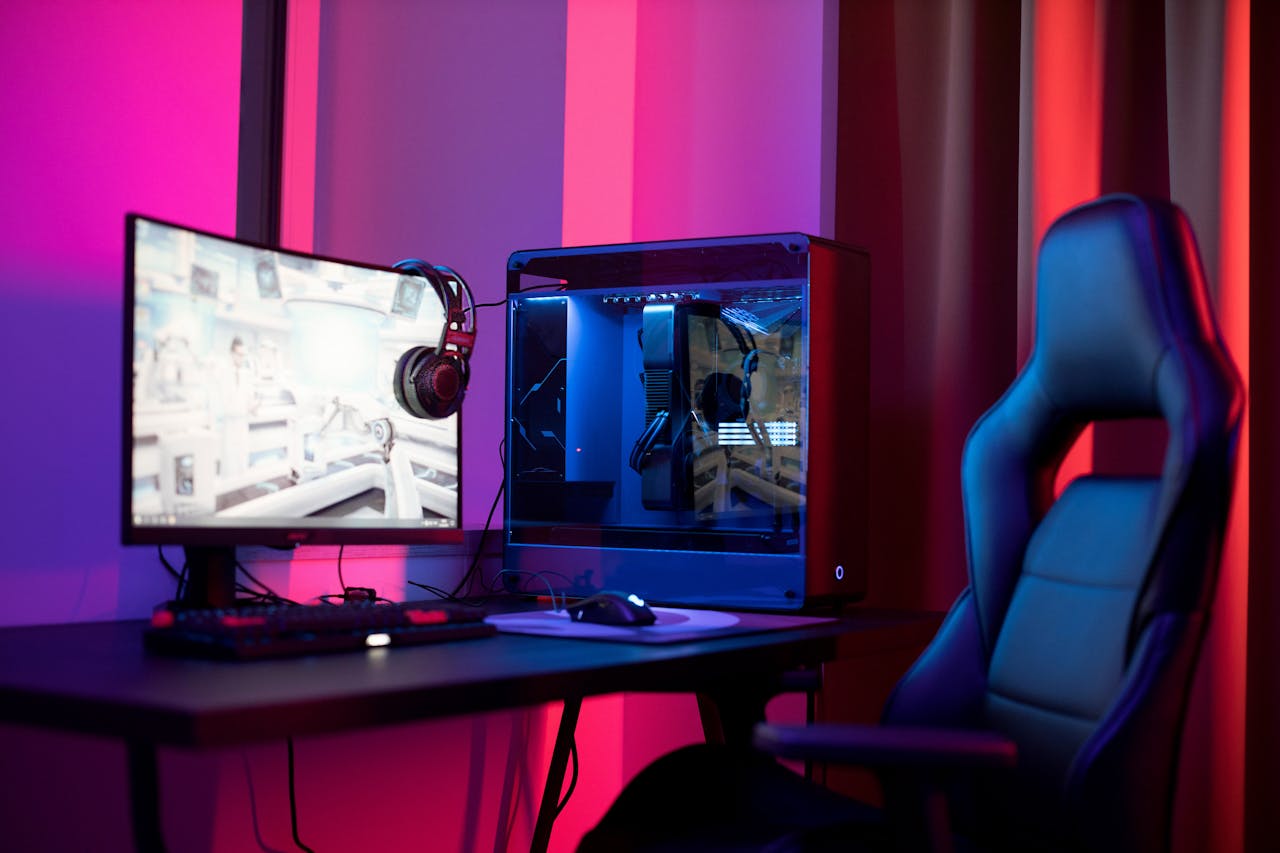 services-01 A sleek gaming setup featuring a high-end PC, widescreen monitor, and ergonomic chair lit by neon lights.